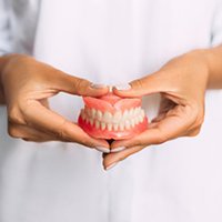 Lady presents viewer with dentures