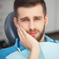 An older man paying for dental implants in Covington