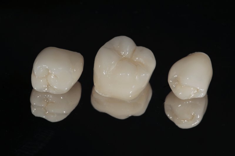 A closeup of ceramic dental crowns against a black background